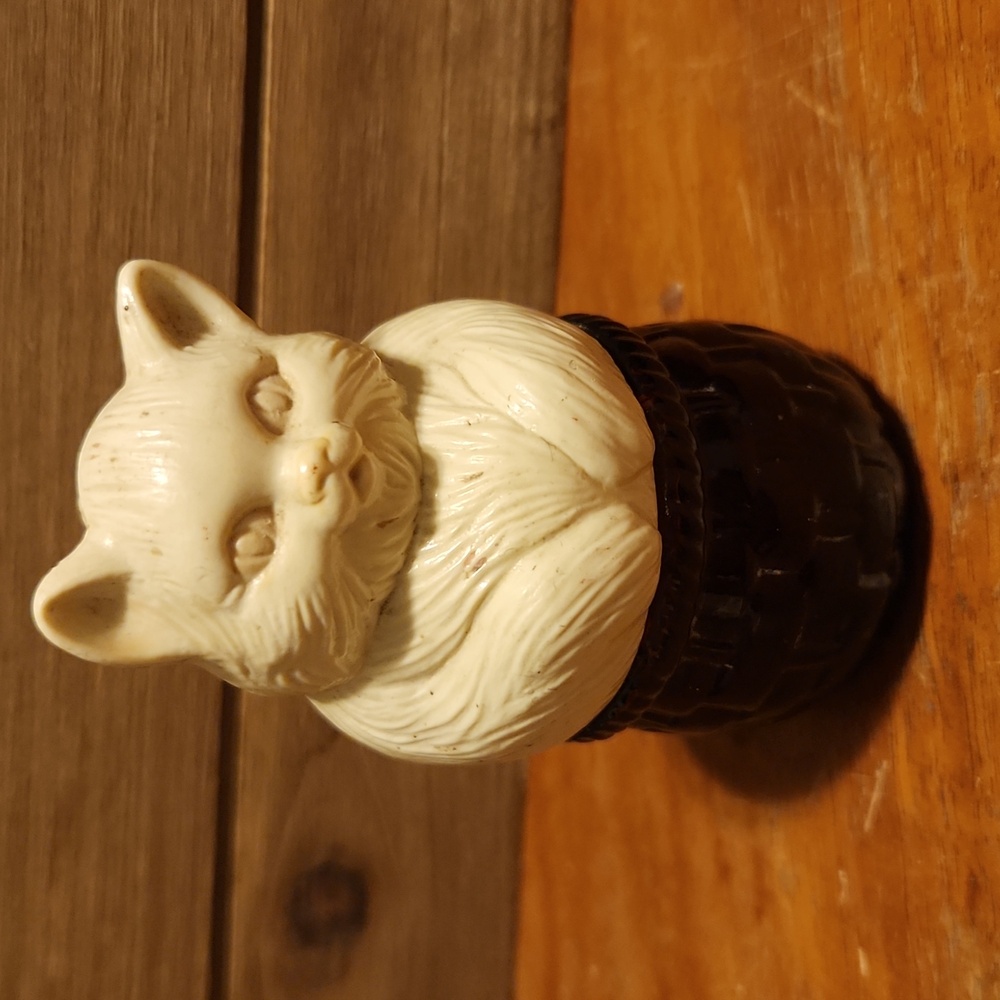 Avon white kitty on a brown glass basket 3.5” tall 2” at widest